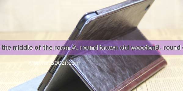 There is a  table in the middle of the room.A. round brown old woodenB. round old brown wo